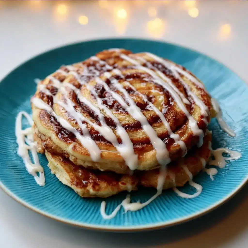 Delicious cinnamon roll pancakes drizzled with cream cheese frosting