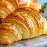 Freshly baked homemade croissants on a wooden table.