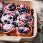 Freshly baked blueberry cinnamon rolls drizzled with icing