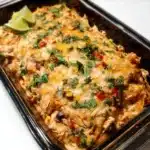 Delicious Chicken Burrito Casserole topped with cheese and fresh ingredients