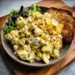 A delicious bowl of crispy egg salad with fresh ingredients and sauces.