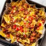 Deliciously crispy Air Fryer Nachos topped with cheese and jalapeños.