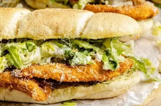 Chicken Caesar Sandwiches feature well-seasoned, crispy chicken, Caesar salad, and Parmesan cheese layered on soft bread.