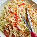 Bowl of creamy coleslaw with fresh vegetables and dressing
