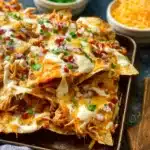 Delicious sheet pan BBQ chicken nachos topped with cheese and jalapeños