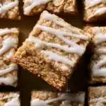 Delicious iced oatmeal cookie bars topped with creamy frosting and oats