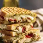 Close-up of a scrumptious Italian Chicken Panini sandwich on a wooden board.