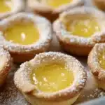 Lemon bar cookie cups topped with lemon zest in a baking dish