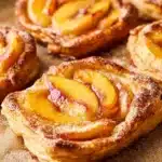 Mini peach and cream cheese tarts garnished with fresh peach slices