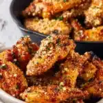 Oven-roasted garlic parmesan wings on a plate garnished with herbs