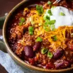 Homemade chili served in a bowl with toppings.