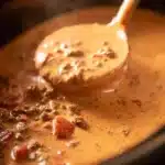 Creamy slow cooker queso dip served in a bowl with tortilla chips