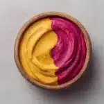 A vibrant smoothie made with fresh fruits and vegetables in a clear glass