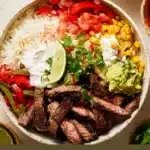 A colorful Steak Fajita Bowl with grilled steak, bell peppers, and toppings