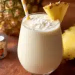Easy 3-ingredient Piña Colada Smoothie served in a glass with fresh garnishes