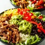 Delicious carnitas burrito bowl packed with pork, rice, and fresh toppings