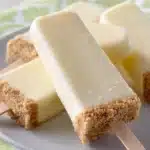 Frozen cheesecake pops on a stick, perfect for a refreshing dessert.