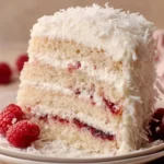 Delicious raspberry layer cake with fresh raspberries and whipped cream topping.