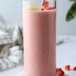 Delicious strawberry banana smoothie in a glass with fresh fruit garnish