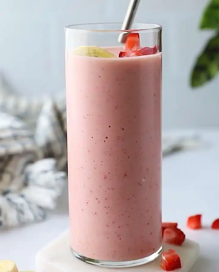 Delicious strawberry banana smoothie in a glass with fresh fruit garnish